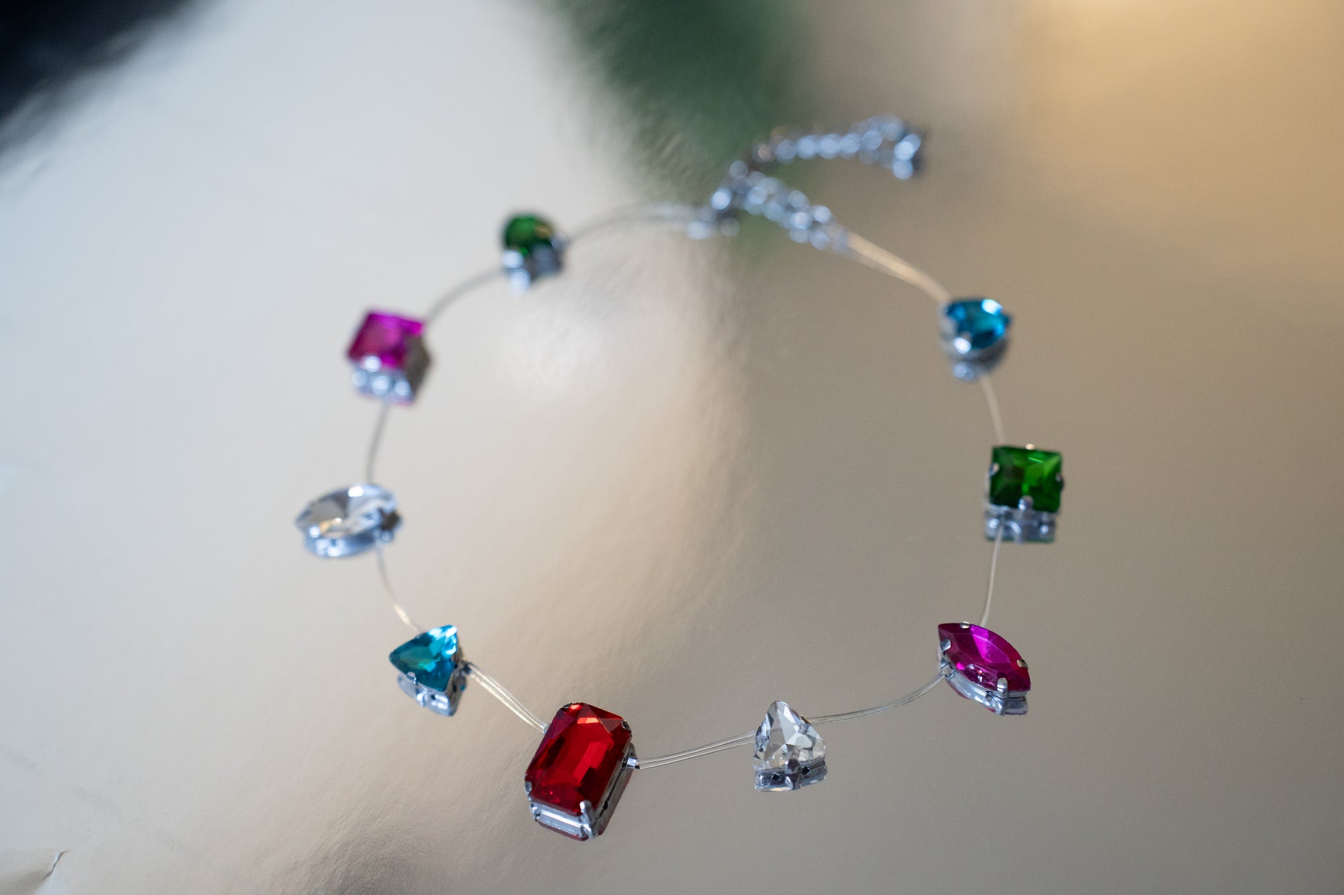 Necklace with colorful gemstones on a reflective surface