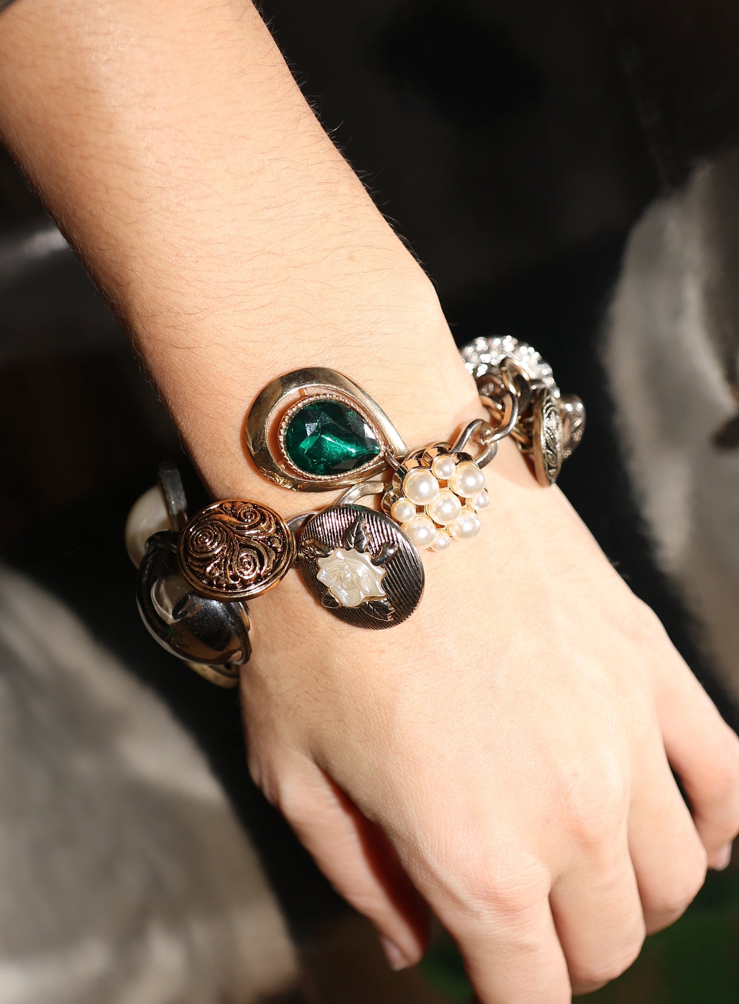 Close-up of a hand wearing multiple bracelets with intricate designs.