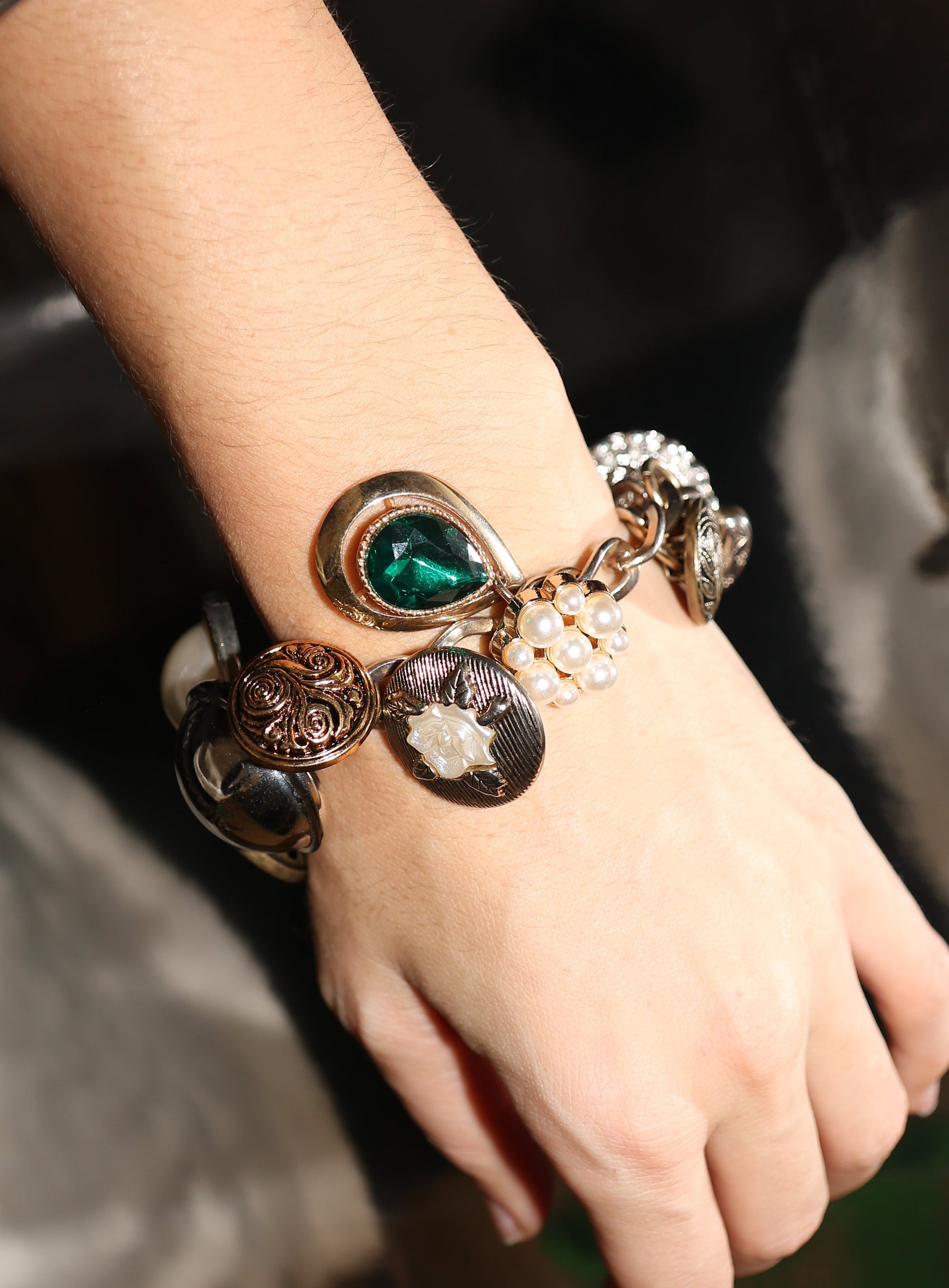 Close-up of a hand wearing multiple bracelets with intricate designs.